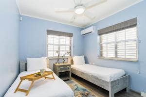 two beds in a room with blue walls at Topaz 8 in Palm-Eagle Beach +52 photos