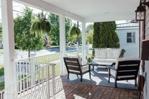 a screened porch with two chairs and a table on it at Skaneateles Boutique Hotel in Skaneateles