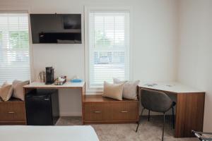a room with a bed and a desk and chairs at Skaneateles Boutique Hotel in Skaneateles