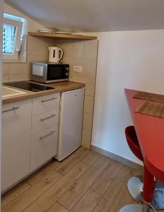 a small kitchen with a counter and a microwave at Apartman Saric K&M in Baška Voda