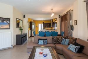 a living room with a couch and a table at AnnaBoutique Villa Beach, Heated Private Pool & BBQ in Kato Daratso