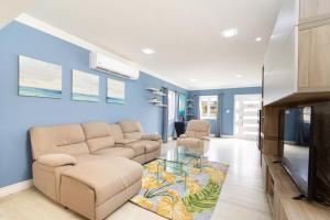 - un salon avec un canapé et une télévision dans l'établissement Solito 52, à Oranjestad