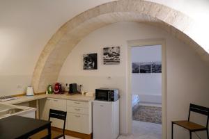 - une cuisine avec une arche et un four micro-ondes dans l'établissement Arco Felice, à Giovinazzo