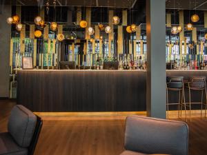 a bar in a restaurant with two stools at Motel One Saarbrücken in Saarbrücken