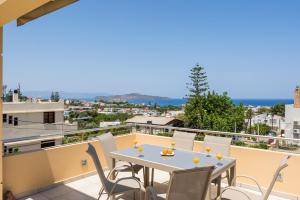 a patio with a table and chairs on a balcony at AnnaBoutique Villa Beach, Heated Private Pool & BBQ in Kato Daratso