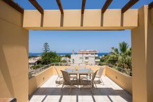 a patio with a table and chairs on a balcony at AnnaBoutique Villa Beach, Heated Private Pool & BBQ in Kato Daratso