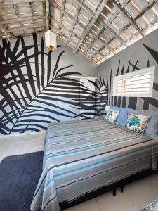 um quarto com uma cama grande e uma pintura na parede em Vila da Sereia hostel e pousada em Icaraí