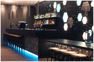 a bar with stools and a counter with drinks at Motel One London-Tower Hill in London