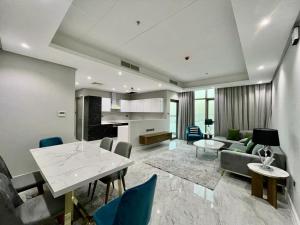 a living room with a table and chairs and a kitchen at Al Safwa 2 in Manama