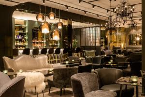a restaurant with chairs and tables and a bar at Motel One Paris-Porte Dorée in Paris