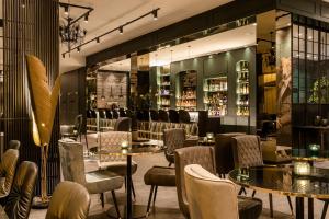a restaurant with tables and chairs and a bar at Motel One Paris-Porte Dorée in Paris