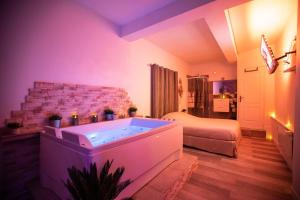 a bathroom with a tub in a room with a bed at Suite and Spa la Perla Bianca in Grabels
