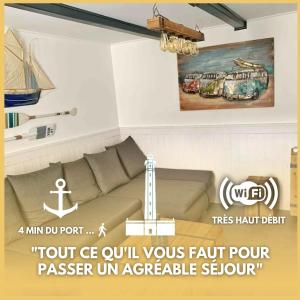 a living room with a couch and a painting on the wall at Le Phare des Baleines in La Flotte