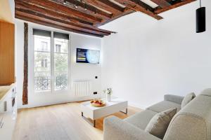 a living room with a couch and a table at Studio 2P renovated rue des Archives Marais Clim 2 in Paris