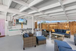 a living room with blue couches and a table at Flirty Flamingo with Private Heated Pool, Game Room, and AMAZING Covered Outdoor Living in Panama City Beach