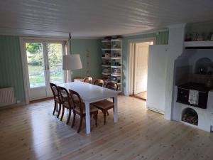 a dining room with a white table and chairs at Nilsstugan in Råda