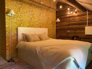 een slaapkamer met een bed en een gele muur bij Nilsstugan in Råda