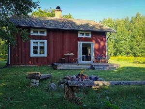 een rood huis met een vuur ervoor bij Nilsstugan in Råda