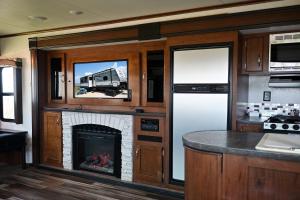 a kitchen with a fireplace in a rv at Bay View Glamping in Bolivar Peninsula