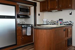 a kitchen with a stainless steel refrigerator and a sink at Bay View Glamping in Bolivar Peninsula
