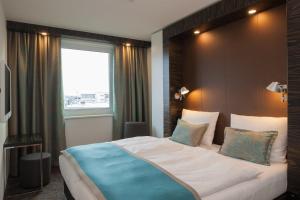 a bedroom with a large bed with a large window at Motel One Frankfurt Messe in Frankfurt/Main