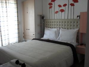 a bedroom with a large bed with red flowers on the wall at La Santre Villa in Amoudara Herakliou
