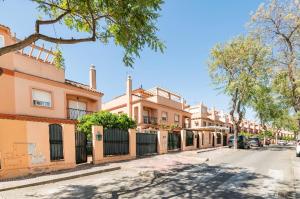 uma fila de casas numa rua com árvores em La casa de Marilo em Tomares