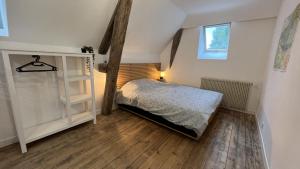 a bedroom with a bed and a wooden floor at Appartement au coeur de la Suisse normande in Thury-Harcourt