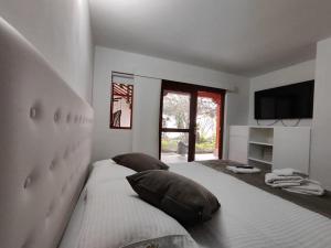 a bedroom with a large bed and a television at Once Once Boutique in Villa de Leyva