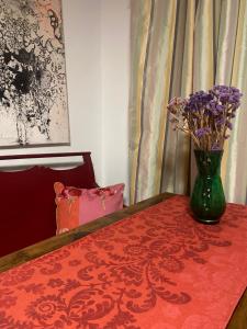 un jarrón verde con flores púrpuras sobre una mesa en Kleine zimmer in luxus wohnung en Schenefeld