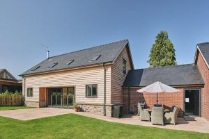 a house with a patio and an umbrella at The Byre 