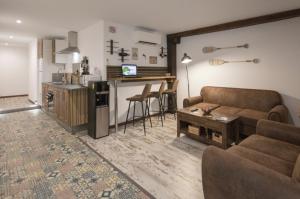 a living room with a couch and a kitchen at Emilysuites - Malaga Centro Historico in Málaga