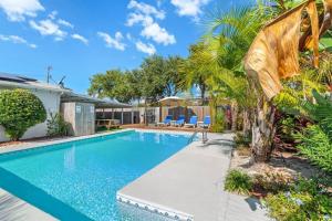 a swimming pool in a home with a palm tree at Flirty Flamingo with Private Heated Pool, Game Room, and AMAZING Covered Outdoor Living in Panama City Beach