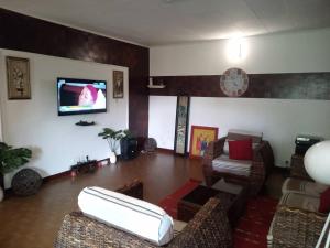 a living room with a couch and a flat screen tv at Comme Chez Soi 1 in Pointe-Noire