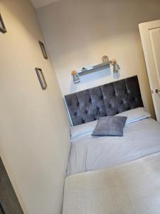 a small bedroom with a bed with a headboard at Saltwater Edge Apartment in Portrush