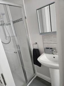 a bathroom with a shower and a sink at Saltwater Edge Apartment in Portrush +5 photos