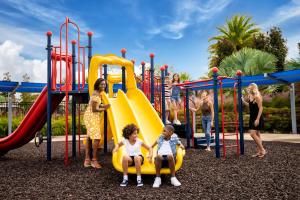 a group of children playing on a playground at Magnificent Condo w/ Reunion Water Park Access near Disney by Spectrum Resort Orlando by Rentyl - B7 #128 in Kissimmee