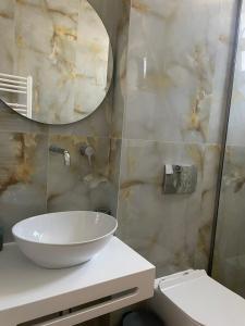 a bathroom with a sink and a mirror and a toilet at Kavala Luxury House in Kavála