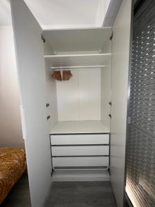 um closet com armários brancos e uma cama em Charmant 2 Pièces em Antibes