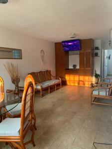 ein Wohnzimmer mit 2 Stühlen und einem Sofa in der Unterkunft Depto con PISCINA PUENTE DEL MAR ACAPULCO in Acapulco