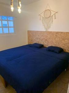 Una cama azul con dos almohadas azules encima. en Depto con PISCINA PUENTE DEL MAR ACAPULCO, en Acapulco