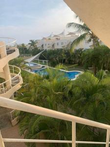een uitzicht op een resort met een zwembad en palmbomen bij Depto con PISCINA PUENTE DEL MAR ACAPULCO in Acapulco