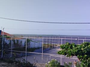 a tennis court with a net in front of the ocean at Pousada Embarcacao in Tutóia