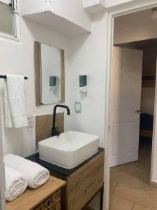 ein Badezimmer mit einem weißen Waschbecken und einem Spiegel in der Unterkunft Depto con PISCINA PUENTE DEL MAR ACAPULCO in Acapulco