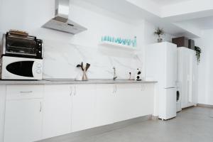 uma cozinha branca com armários brancos e um micro-ondas em Ana Mari's Studio in Frigiliana em Frigiliana