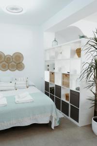 um quarto branco com uma cama e uma parede de prateleiras em Ana Mari's Studio in Frigiliana em Frigiliana