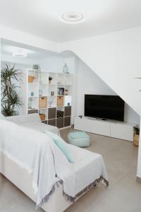 um quarto branco com uma cama e uma televisão de ecrã plano em Ana Mari's Studio in Frigiliana em Frigiliana