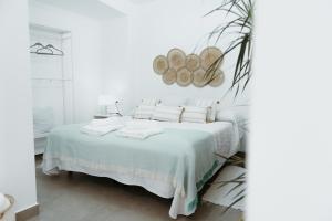 - une chambre blanche avec un lit et des draps blancs dans l'établissement Ana Mari's Studio in Frigiliana, à Frigiliana