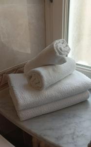 una pila di asciugamani seduta su un tavolo in bagno di Darling Home a Merano