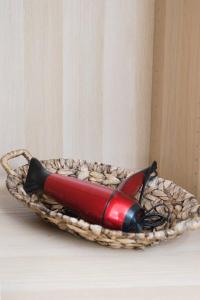 a red bottle in a basket on a table at Helios Guest House in Faraí